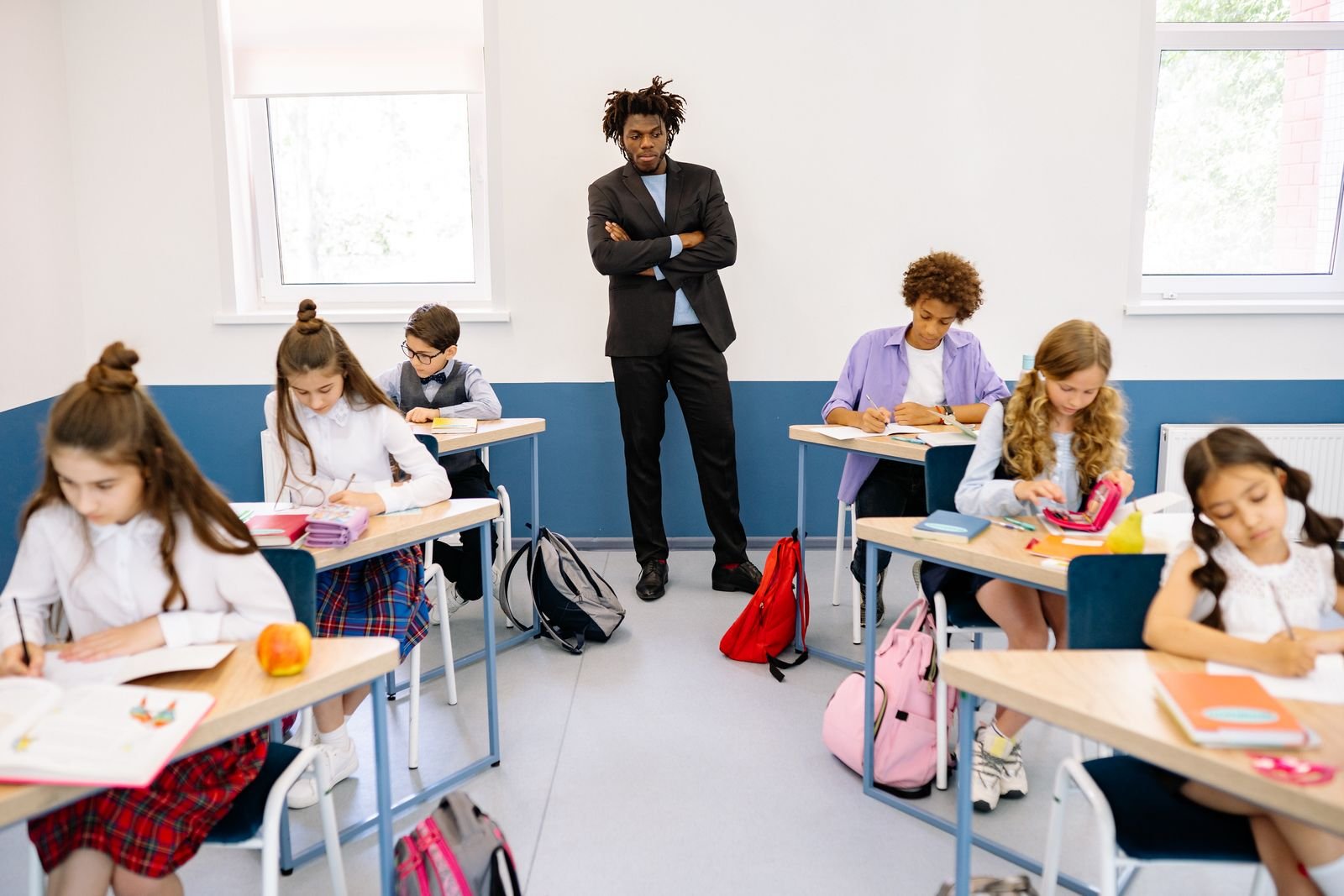 Teacher supporting elementary students in a classroom