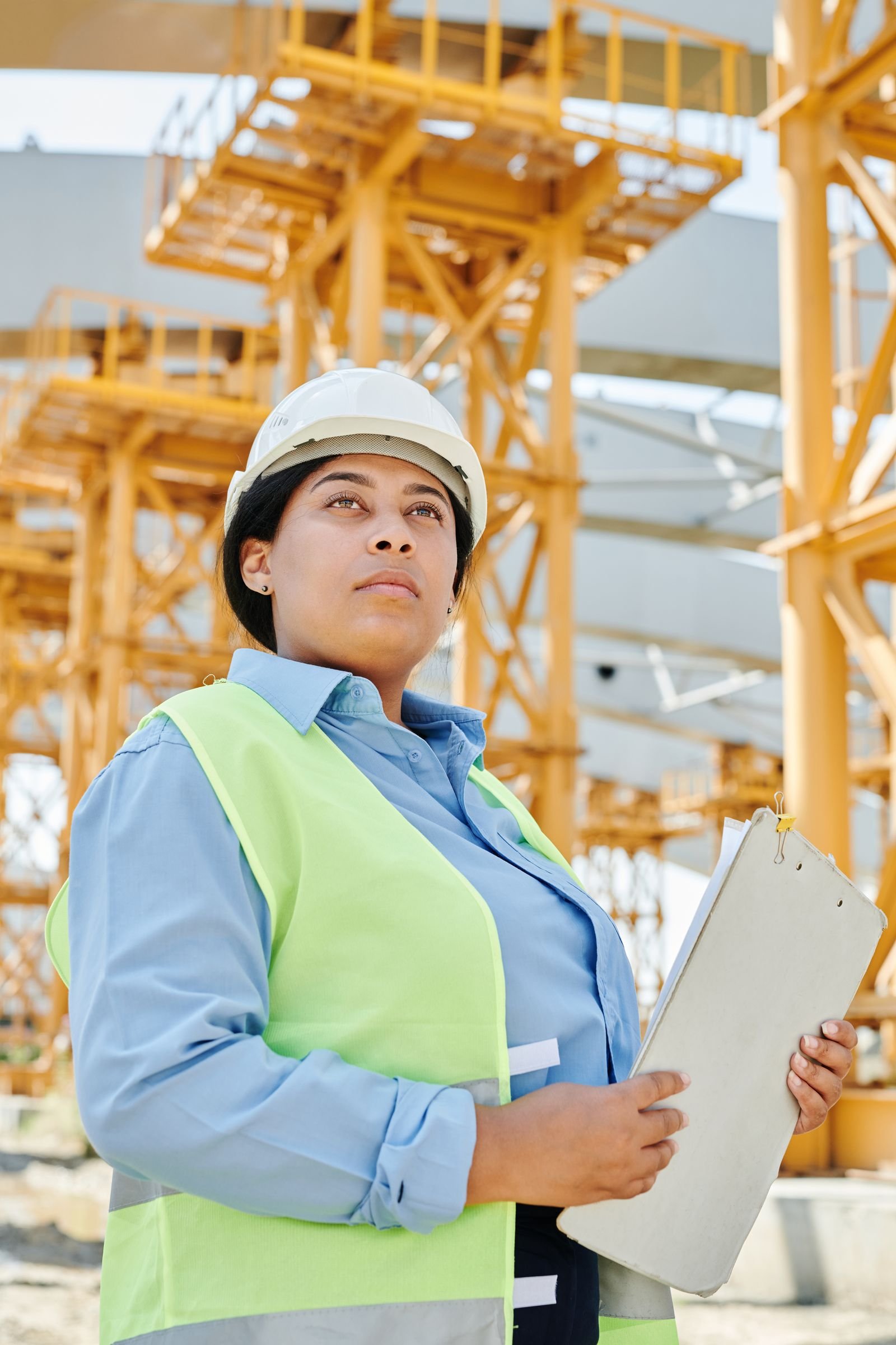 Worker in hard hat and safety vest doing a site safety check